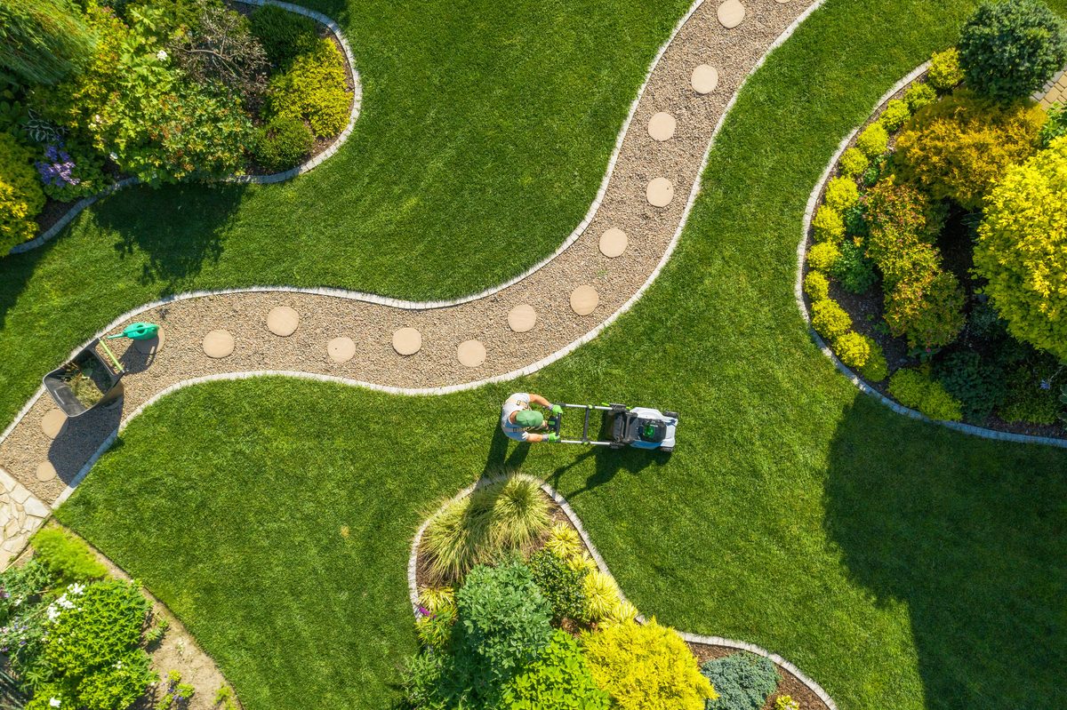 Aerial view of beautifully manicured garden with winding pathway and lawn maintenance