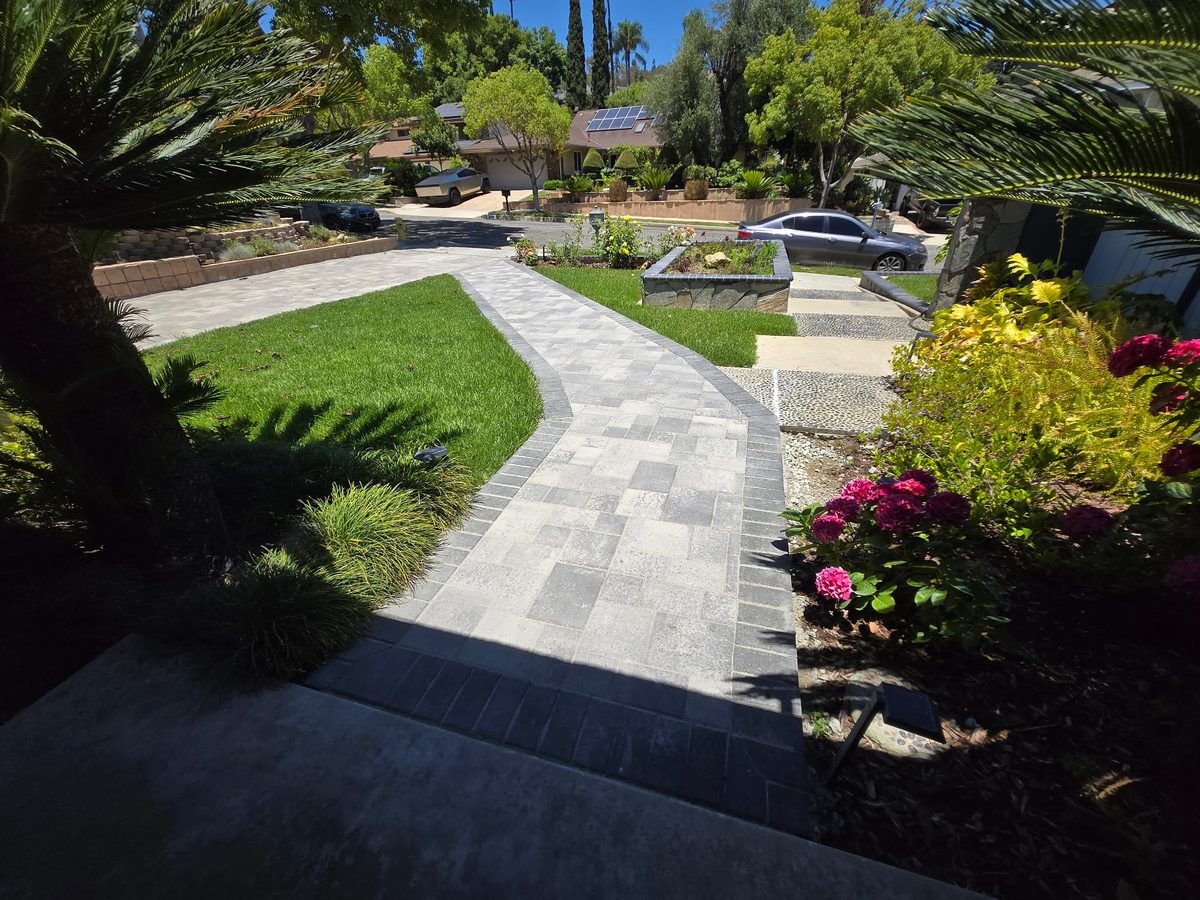 Front yard with paver driveway, turf and colorful planting